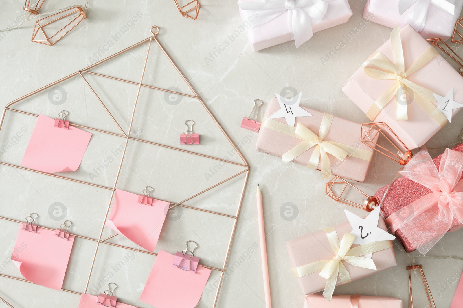 Photo of Flat lay composition with gift boxes and paper notes  on grey marble table. Creating advent calendar