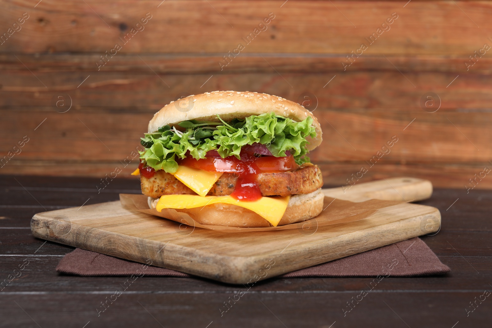 Photo of Delicious burger with tofu, fresh vegetables and sauce on wooden table