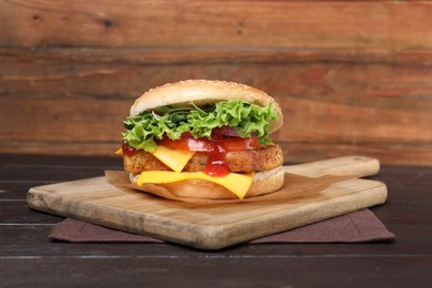 Photo of Delicious burger with tofu, fresh vegetables and sauce on wooden table