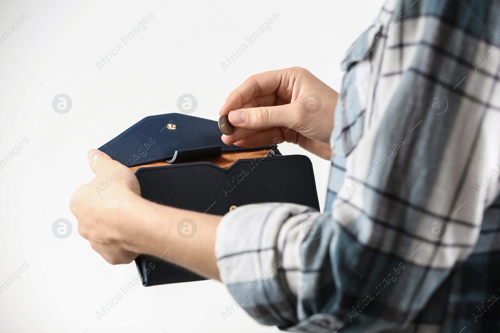 Photo of Woman holding coin into wallet on light background, closeup. Money savings