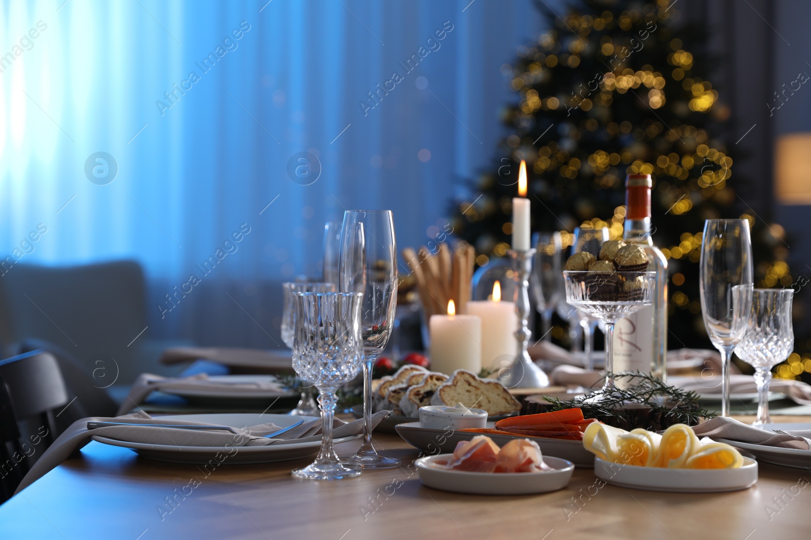 Photo of Christmas table setting with festive decor and dishware in room