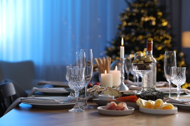 Christmas table setting with festive decor and dishware in room