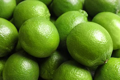 Photo of Fresh ripe green limes as background, closeup view