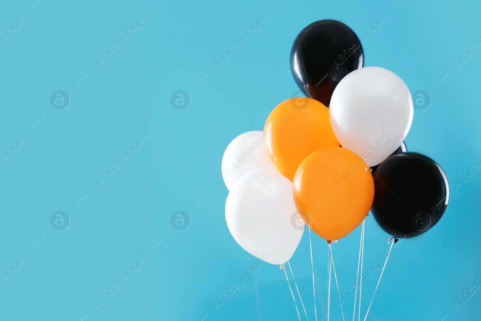 Photo of Colorful balloons on blue background, space for text. Halloween party