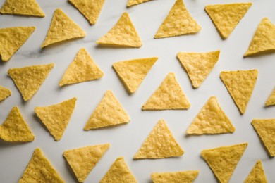 Flat lay composition of tasty tortilla chips (nachos) on white table