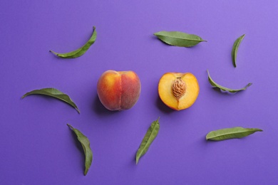 Flat lay composition with fresh peaches on purple background