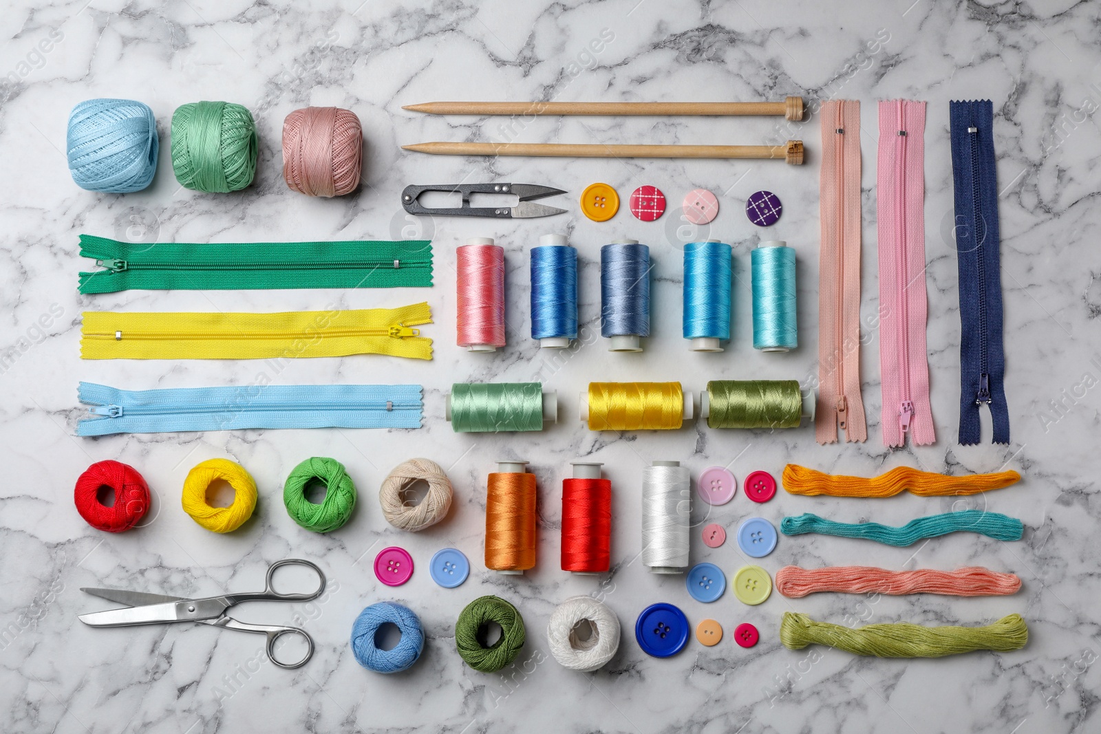 Photo of Flat lay composition with color sewing threads on marble background