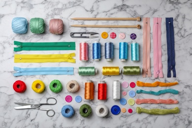 Flat lay composition with color sewing threads on marble background