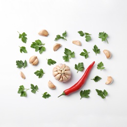 Flat lay composition with green parsley, pepper and garlic on white background