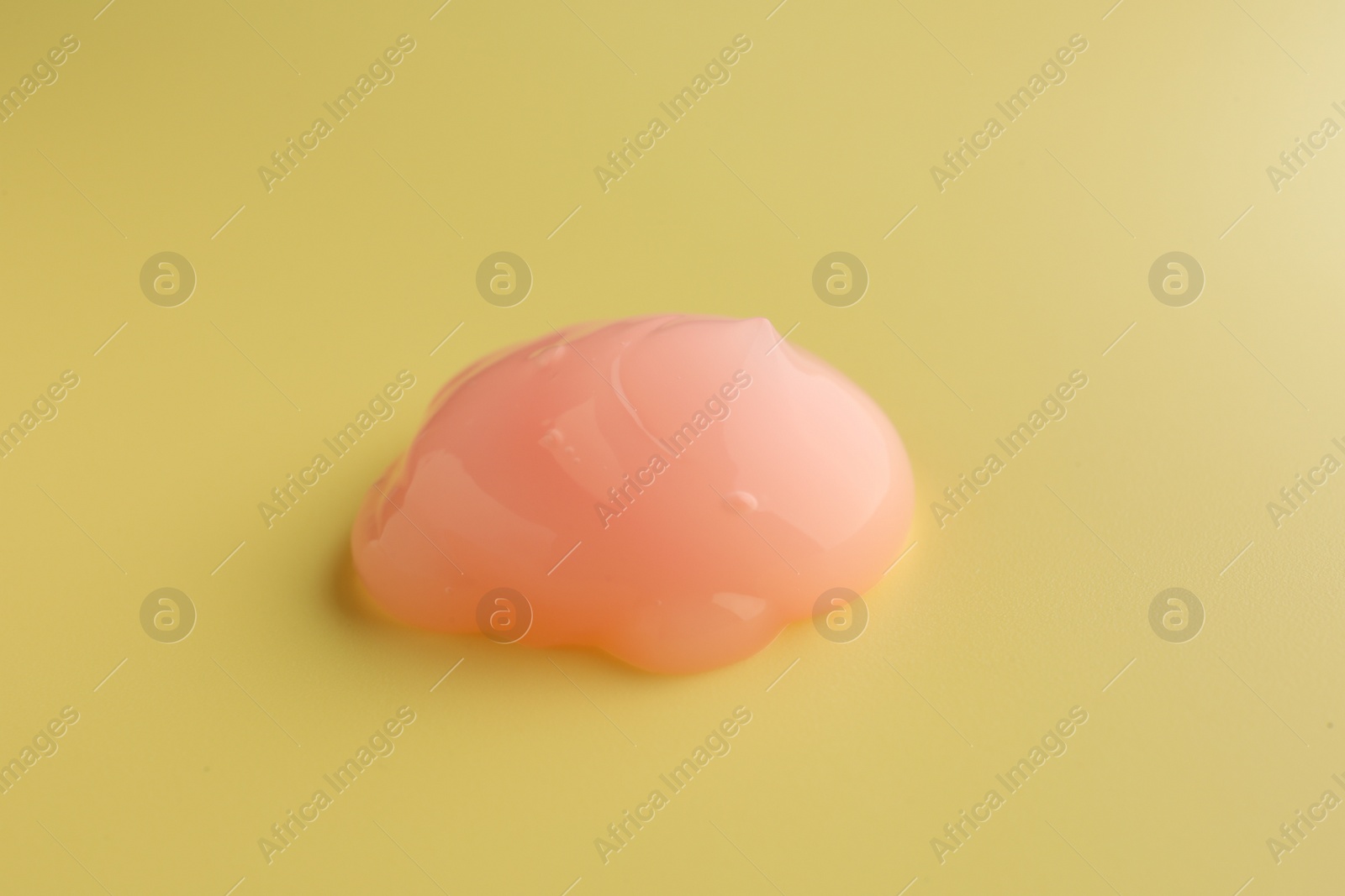 Photo of Sample of face cream on yellow background, top view