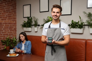 Waiter with terminal for contactless payment in cafe