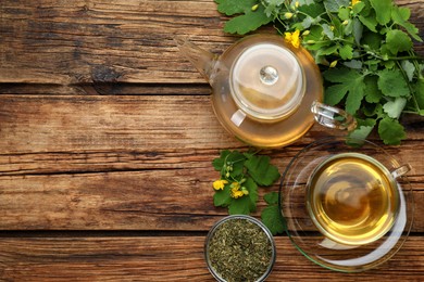 Photo of Aromatic celandine tea and flowers on wooden table, flat lay. Space for text