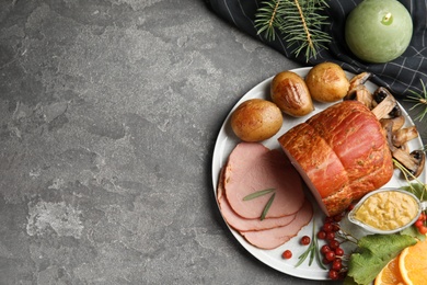 Photo of Flat lay composition with delicious ham on grey table, space for text. Christmas dinner