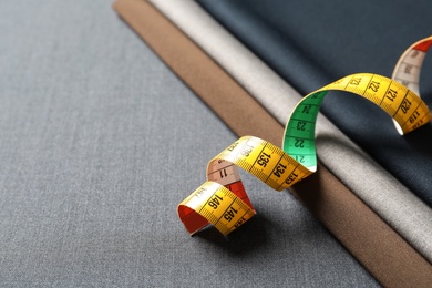 Photo of Measuring tape on fabric, closeup. Tailoring equipment