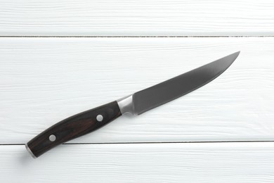 Photo of One sharp knife on white wooden table, top view