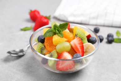 Photo of Delicious fresh fruit salad in bowl on light table
