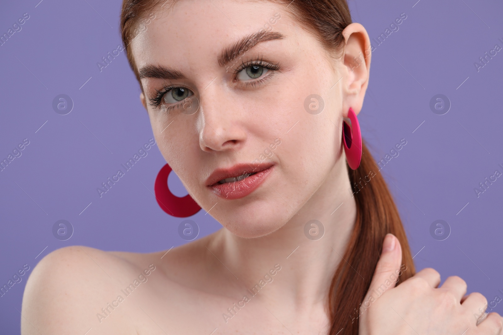 Photo of Portrait of beautiful woman with freckles on purple background, closeup