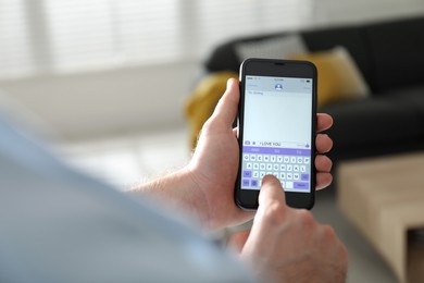 Man writing message with text I Love You on smartphone against blurred background, closeup