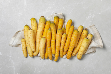 Many raw white and yellow carrots on light grey marble table, flat lay