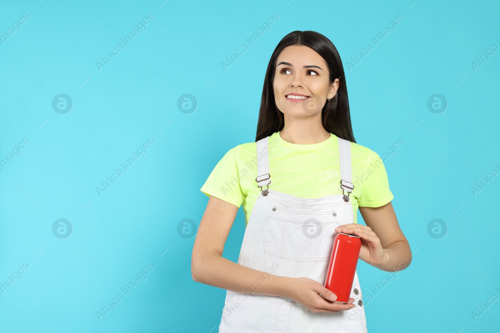Photo of Beautiful happy woman holding red beverage can on light blue background. Space for text