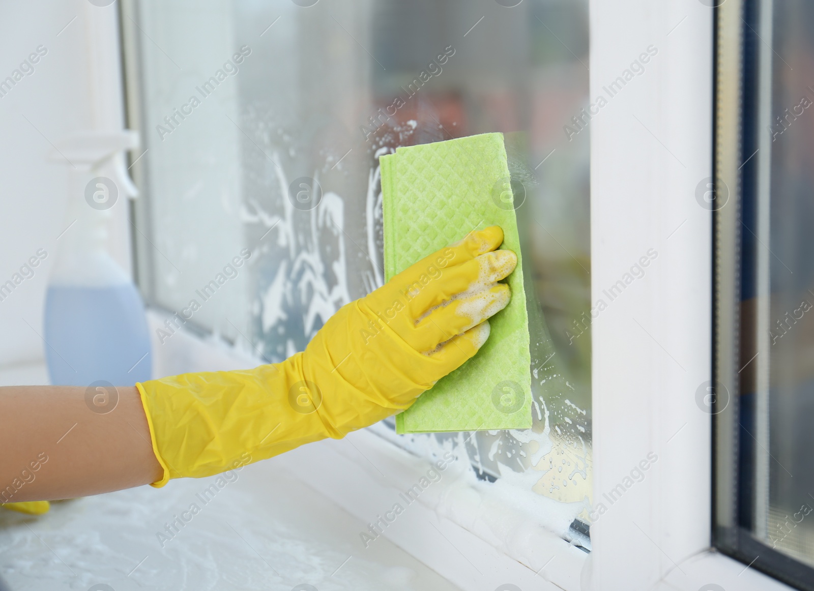 Photo of Woman cleaning window with rag, closeup view