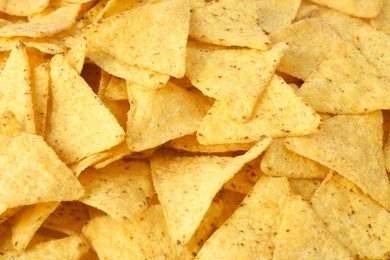 Photo of Tasty Mexican nachos chips as background, closeup