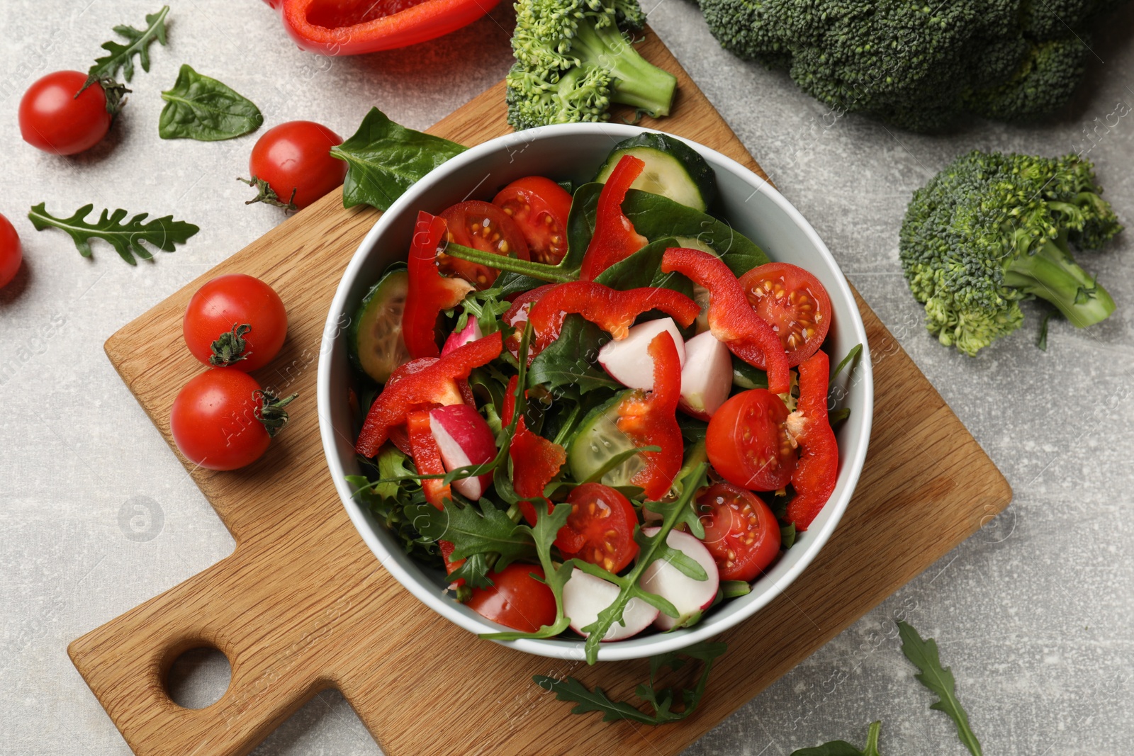 Photo of Tasty fresh vegetarian salad on light grey table, flat lay