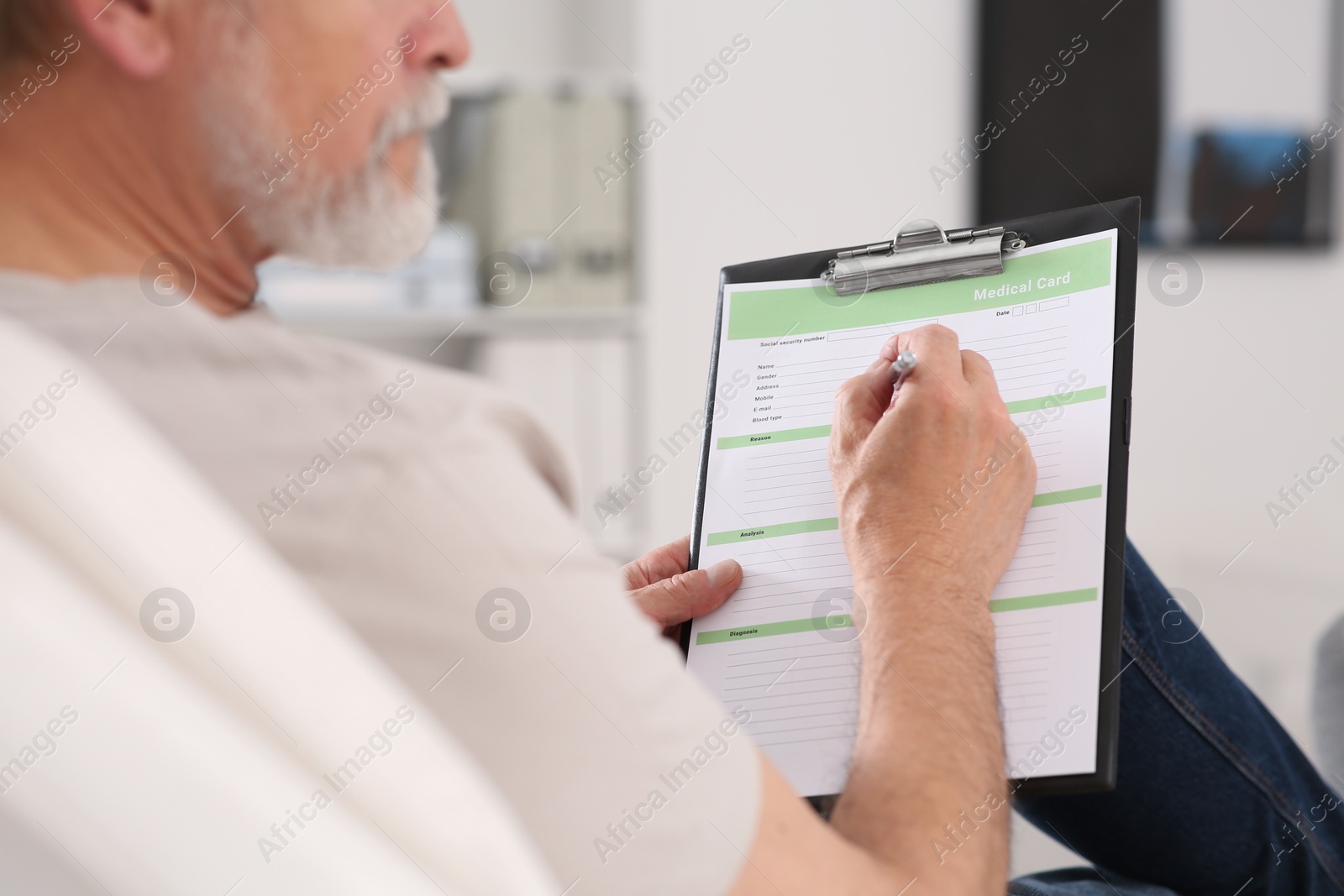 Photo of Patient filling his medical card in clinic, closeup