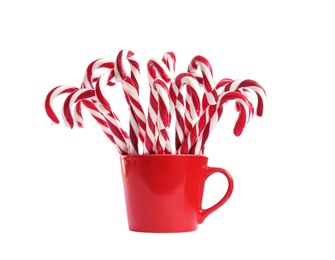 Many sweet candy canes in red cup on white background. Christmas treat