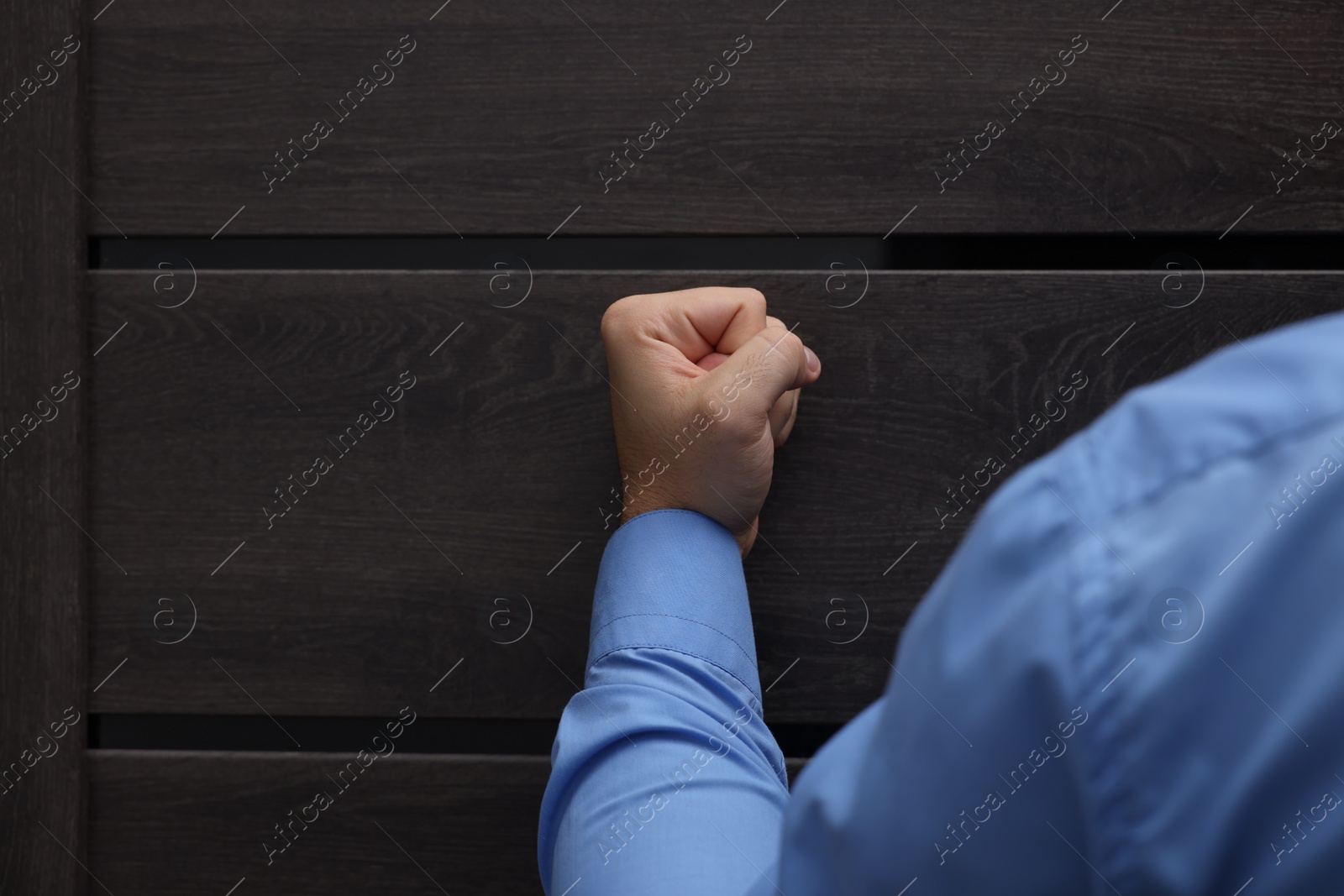 Photo of Collection agent knocking on wooden door, closeup