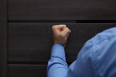 Collection agent knocking on wooden door, closeup