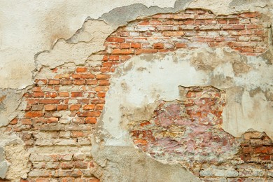 Photo of Old brick wall with cracked paint as background