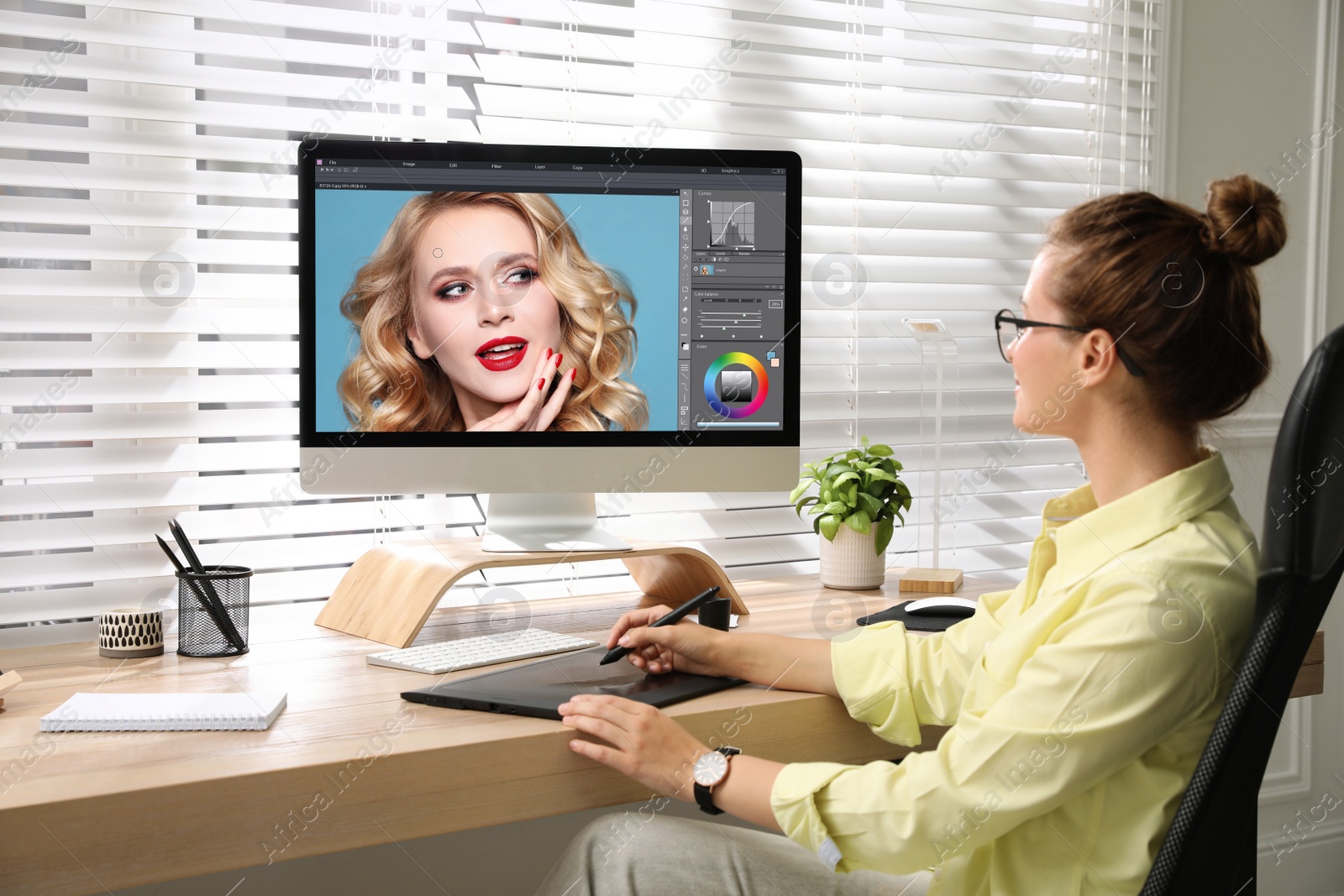 Photo of Professional retoucher working on graphic tablet at desk in office