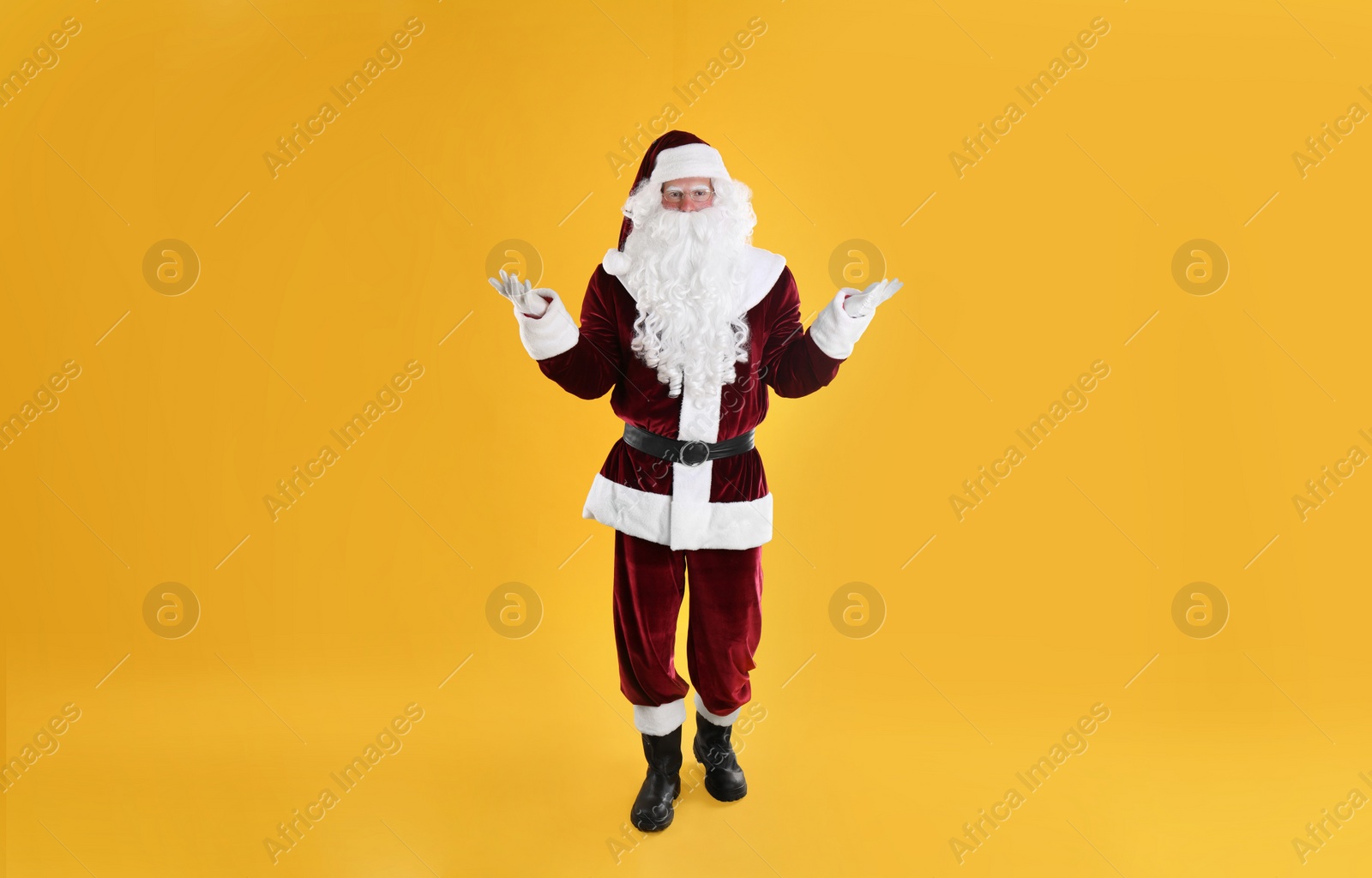 Photo of Full length portrait of Santa Claus on yellow background