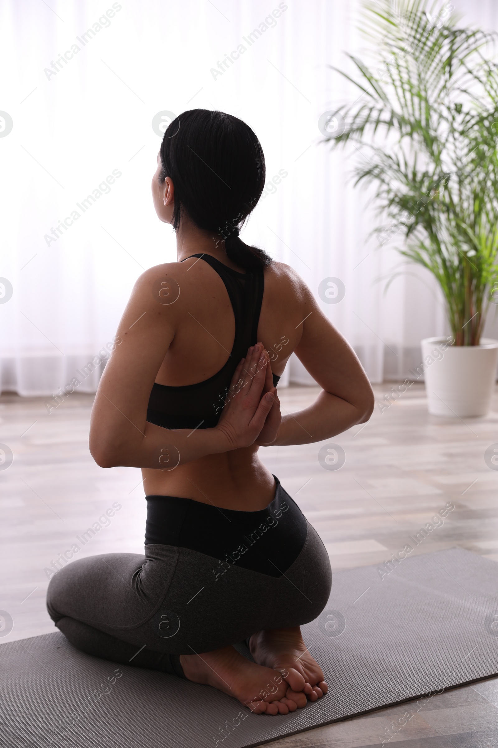 Photo of Young woman practicing seiza asana in yoga studio. Vajrasana pose