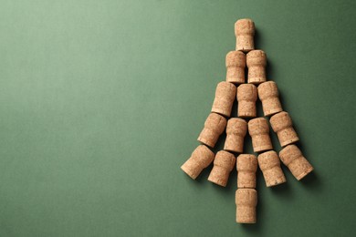 Christmas tree made of wine corks on green background, top view. Space for text
