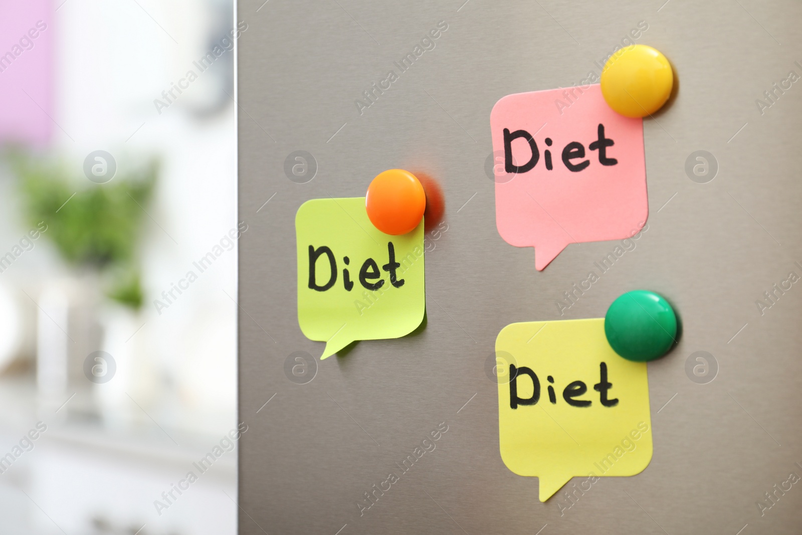 Photo of Notes with word "Diet" and magnets on refrigerator door in kitchen. Space for text