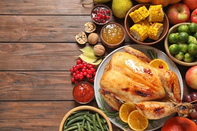 Photo of Flat lay composition with turkey on wooden background, space for text. Happy Thanksgiving day