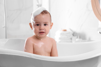 Photo of Cute little baby in bathtub at home
