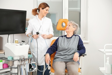 Senior woman visiting professional otolaryngologist in clinic. Hearing disorder