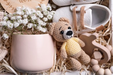 Photo of Baby booties, toys and flowers in box, top view