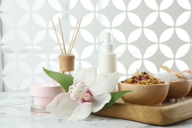 Photo of Beautiful composition with different spa products and orchid on white marble table