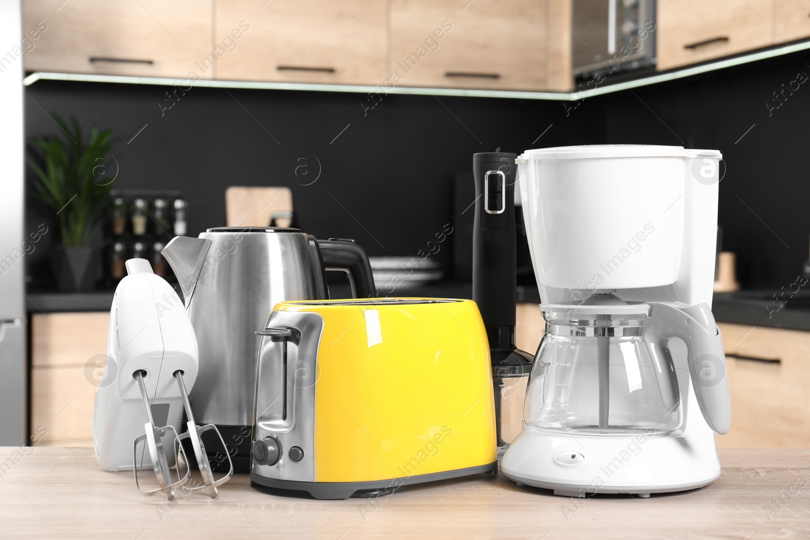 Photo of Modern domestic appliances on wooden table in kitchen