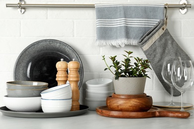 Photo of Set of clean tableware on white countertop in kitchen