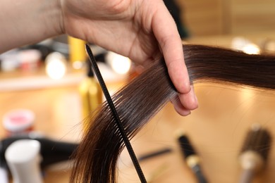 Hairdresser combing client's hair in salon, closeup