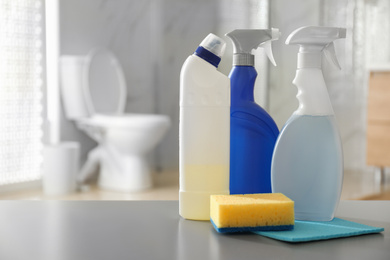 Photo of Cleaning supplies and toilet bowl in bathroom. Space for text