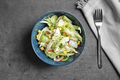 Photo of Flat lay composition with healthy cabbage salad on dark table