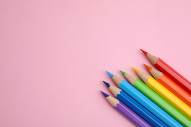 Colorful wooden pencils on pink background, flat lay. Space for text