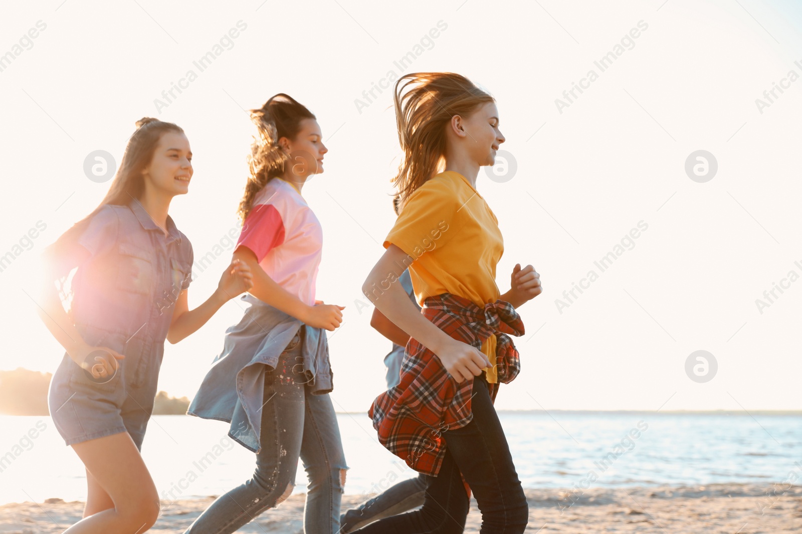 Photo of Group of children running on beach. Summer camp