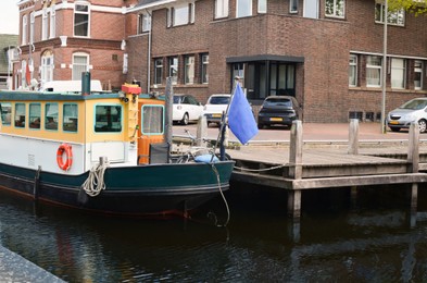 Photo of Beautiful city canal with moored boat at pier
